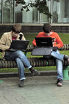 Minsk, Belarus: two students working on their laptop computers on a street bench - photo by A.Dnieprowsky