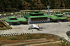 Bhutan - Paro: Paro airport, seen from a nearby hill - terminal and airside - Druk Air Airbus A319-100 - photo by A.Ferrari