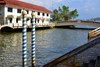 Bandar Seri Begawan, Brunei Darussalam: arch and spiral painted mooring pillars where the Subok river meets the Brunei river - photo by M.Torres