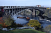 New Brunswick, Canada: tugboat pushing barge down the St. Lawrence - arch bridge - photo by C.Lovell