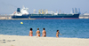 La Pineda, Vila-seca, Costa Dorada, Tarragona, Catalonia: women on the beach and the tanker Iblea, Oil and Chemical Carrier built at Namura Shipbuilding in Imari, Japan - photo by B.Henry