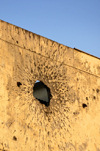 Brazzaville, Congo: war damage - impact of an RPG on the wall of a colonial building, a few bullet holes are also included, for good measure - Avenue Amilcar Cabral, Quartier de la Plaine - photo by M.Torres