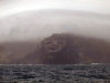 Crozet islands - Possession island:  the appropriately named Pointe Sombre stands out in contrast to the mist shrouded hills (photo by Francis Lynch)