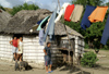Cuba - Holgun province - village scene - two women, a husband, pigs and a white thatched house - photo by G.Friedman