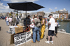 Weymouth, Dorset, England: people buying fresh line caught sea bass off local man in Brewers Quay - photo by I.Middleton