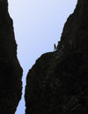 53 Franz Josef Land: Person climbing twin spires, Cape Tegethoff, Hall Island - photo by B.Cain