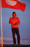 Greenland, Apussuit: skier juggling in front of the Greenland flag - photo by S.Egeberg