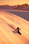 Greenland, Apussuit: snowboarder carving turns on steep slope - photo by S.Egeberg