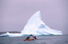 Greenland, Sondre Stromfjod: kayakers paddling past an iceberg - photo by S.Egeberg