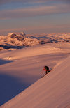 Greenland, Apussuit: skier carving turns on steep slope at sunset - photo by S.Egeberg