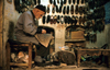 Iran - Yazd: shoemaker at work in the bazaar - cobbler - photo by W.Allgower