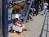 Kosovo - Pec / Peja: 'Try the joys of life' - beggar with sign and baby - photo by J.Kaman