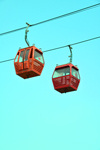 Erbil / Hewler, Kurdistan, Iraq: Shanadar Park - cable car, the Erbil Teleferique - cables and two cabins against blue sky - photo by M.Torres