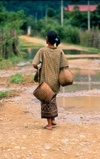 Laos - Vang Vieng - woman walking with jars - photo by K.Strobel