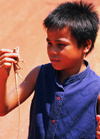 Laos: a young boy caught a lizard to cook it - photo by E.Petitalot