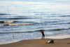 Latvia - Ventspils: angler struggling with a fish - beach (photo by A.Dnieprowsky)