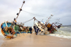 Nouakchott, Mauritania: people look at a fishing trawler stranded on the beach of the fishing harbor - Eishou Maru II tilted 45 and half covered in sand - Port de Peche - photo by M.Torres