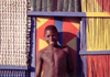Mozambique / Moambique - Benguerra island, Inhambane province: smiling boy and colourful house / rapaz sorridente e casa colorida - photo by F.Rigaud