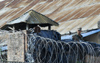 Kathmandu, Nepal: a soldier behind razor wire in a Nepalese army supervision post - concertina wire - photo by E.Petitalot