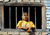 Kathmandu, Nepal: a boy behind bars looks outside - photo by E.Petitalot