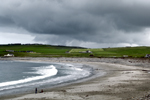 Orkney island - Skara Brae- beach - two boys play in the sand oblivious to the waves and storm rollingin - photo by Carlton McEachern