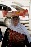 Hebron, West Bank, Palestine: Palestinian woman in traditional dress transporting a box of Israeli tomatoes - photo by J.Pemberton