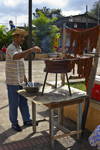 man grilling meat for sale - Portobello, Coln, Panama, Central America - photo by H.Olarte