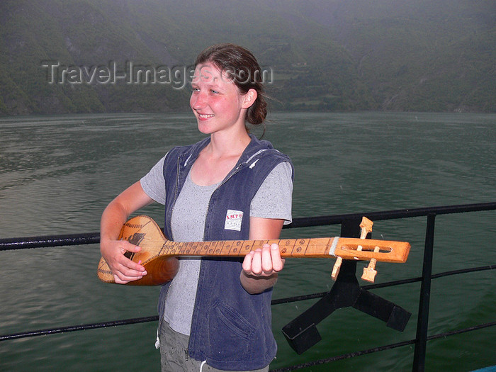albania128: Fierzë - Pukë, Shkodër county, Albania: girl playing typical Albanian musical instrument with 3 courses of metal strings - sharki / sargija - photo by J.Kaman - (c) Travel-Images.com - Stock Photography agency - Image Bank