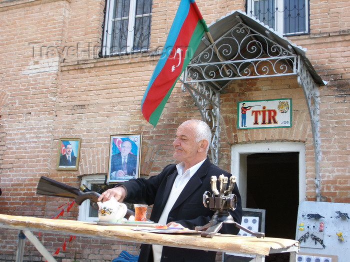 azer442: Sheki / Shaki - Azerbaijan: man recruiting for target practice - Azeri flag and the Aliyevs in the background - photo by N.Mahmudova - (c) Travel-Images.com - Stock Photography agency - Image Bank