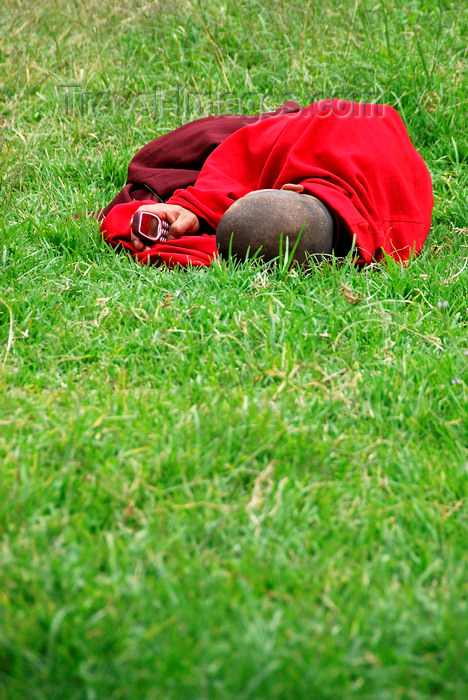 bhutan406: Bhutan, Paro, Monk on grass outside Paro Dzong with cellphone - photo by J.Pemberton - (c) Travel-Images.com - Stock Photography agency - Image Bank