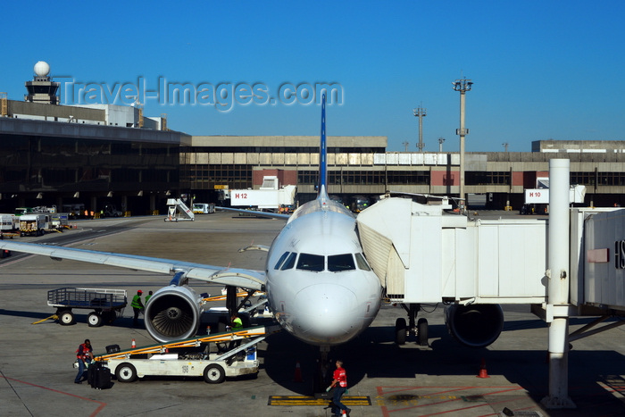 brazil132: São Paulo, Brazil: nose view of an airliner parked at a jet bridge with the groundcrew servicing it - São Paulo / Guarulhos International Airport - aka GRU Airport and Governador André Franco Montoro International Airport - terminal building and control tower in the background - photo by M.Torres - (c) Travel-Images.com - Stock Photography agency - Image Bank