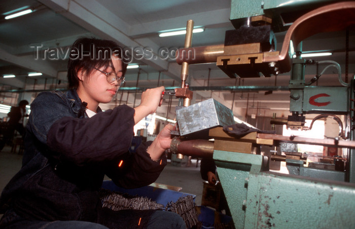 china250: Dongguan, Guangdong province, China: metal worker operating a machine - Chinese factory worker - photo by B.Henry - (c) Travel-Images.com - Stock Photography agency - Image Bank