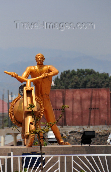 congo-dr41: Goma, Nord-Kivu, Democratic Republic of the Congo: gilded statue of a cargo bike and its pusher, carrying the globe - roundabout center celebrating 50 years of Congolese independence - local trottinette called a chuckadoo, the symbol of Goma - photo by M.Torres - (c) Travel-Images.com - Stock Photography agency - Image Bank