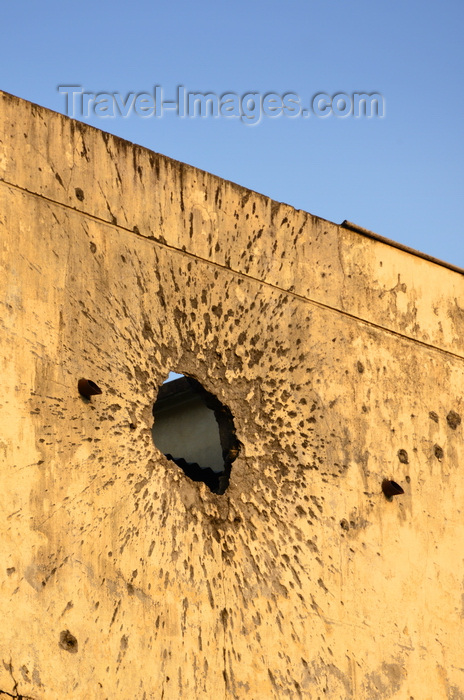 congo32: Brazzaville, Congo: war damage - impact of an RPG on the wall of a colonial building, a few bullet holes are also included, for good measure - Avenue Amilcar Cabral, Quartier de la Plaine - photo by M.Torres - (c) Travel-Images.com - Stock Photography agency - Image Bank