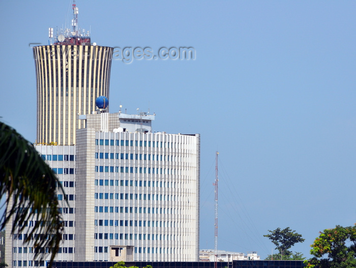 congo64: Brazzaville, Congo: building of the National Petroleum Company of the Congo, SNPC, Société nationale des pétroles du Congo - in the background the Nabemba tower / Elf Tower - palm tree leaf in the foreground - photo by M.Torres - (c) Travel-Images.com - Stock Photography agency - Image Bank