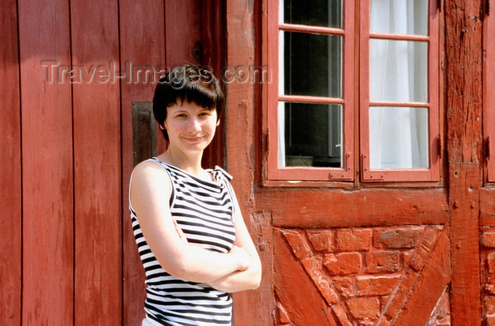 denmark31: Odense, Funen island, Syddanmark, Denmark: smiling young woman posing in front of an old timber framed house - photo by K.Gapys - (c) Travel-Images.com - Stock Photography agency - Image Bank