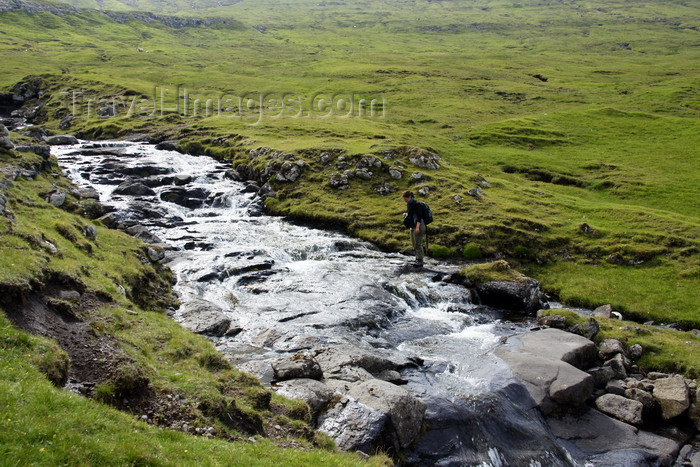 faeroe82: Vágar island, Faroes: hiker crossing a stream on the moorlands - photo by A.Ferrari - (c) Travel-Images.com - Stock Photography agency - Image Bank
