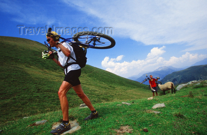 france906: Chamonix, Haute-Savoi, Rhône-Alpes, France: a mountainbiker carrying his bike on the trail while other negotiates passage with a sheep - photo by S.Egeberg - (c) Travel-Images.com - Stock Photography agency - Image Bank