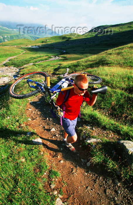 france907: Chamonix, Haute-Savoi, Rhône-Alpes, France: green slopes and mountainbiker carrying his bike on the trail of Tour du Mont Blanc - photo by S.Egeberg - (c) Travel-Images.com - Stock Photography agency - Image Bank