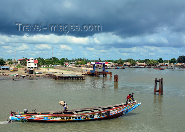 gambia79: Barra, The Gambia: wooden fishing boat on the River Gambia estuary, passing in front of Barra's main pier - dark sky - photo by M.Torres - (c) Travel-Images.com - Stock Photography agency - Image Bank