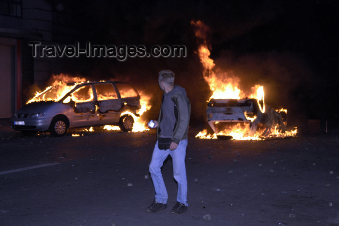 germany282: Germany - Berlin: riots on May 1st - pedestrian passes burning cars - photo by W.Schmidt - (c) Travel-Images.com - Stock Photography agency - Image Bank