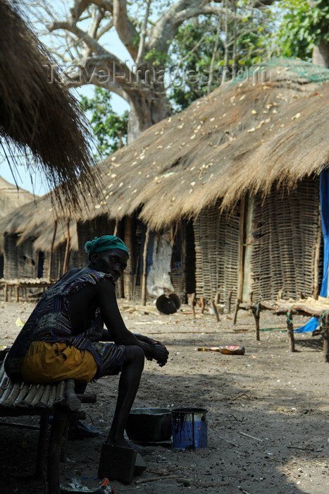 guinea-bissau134: Rubane Island, Bijagós Archipelago - UNESCO biosphere reserve, Bubaque sector, Bolama region, Guinea Bissau / Guiné Bissau: woman in her village, wooden houses with thatched roofs, everyday life / mulher na sua tabanca, cubatas de madeira e palha, vida quotidiana - photo by R.V.Lopes - (c) Travel-Images.com - Stock Photography agency - Image Bank