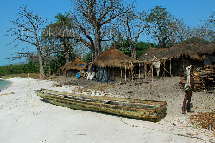 guinea-bissau138: Rubane Island, Bijagós Archipelago - UNESCO biosphere reserve, Bubaque sector, Bolama region, Guinea Bissau / Guiné Bissau: village scene, wood and straw huts, beach, child, canoe, everyday life / aldeia, casas de madeira e palha, praia, criança, canoa, vida quotidiana - photo by R.V.Lopes - (c) Travel-Images.com - Stock Photography agency - Image Bank