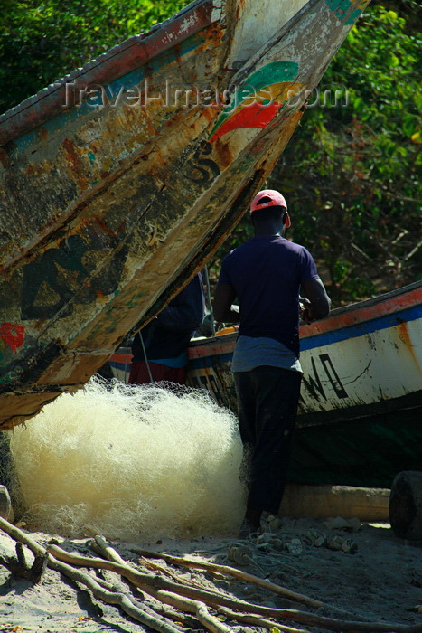 guinea-bissau187: Praia de Varela / Varela beach, Cacheu region, Guinea Bissau / Guiné Bissau: young fisherman repairing nets, Traditional fishing  boats / jovem pescador a reparar redes de pesca, barcos de pesca tradicionais - photo by R.V.Lopes - (c) Travel-Images.com - Stock Photography agency - Image Bank