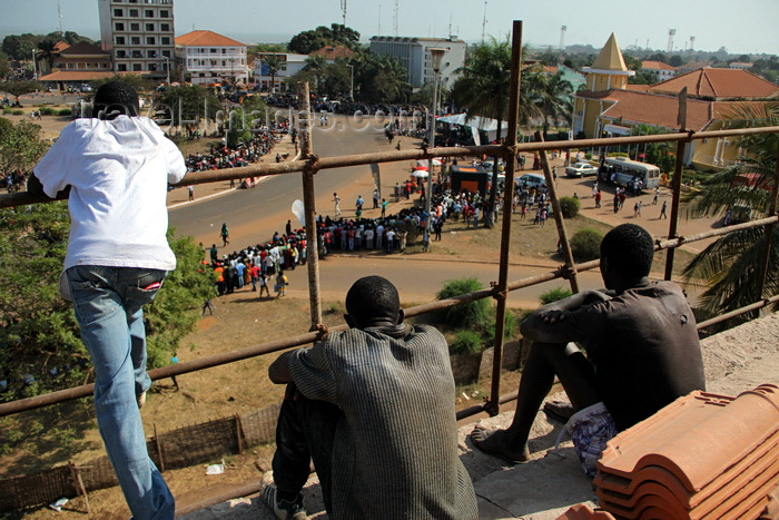 guinea-bissau86: Bissau, Guinea Bissau / Guiné Bissau: Amílcar Cabral ave., Empire Square, Carnival, men watching from roof of the Presidential palace - on the right the old Museum, now the PMs office / Avenida Amilcar Cabral, Praça do Império, homem a assistir do telhado do palácio da presidência - à direita o antigo Museu de Bissau, agora a 'Primatura', gabinete do Primeiro Ministro, projecto do Gabinete de Urbanização Colonial - photo by R.V.Lopes - (c) Travel-Images.com - Stock Photography agency - Image Bank