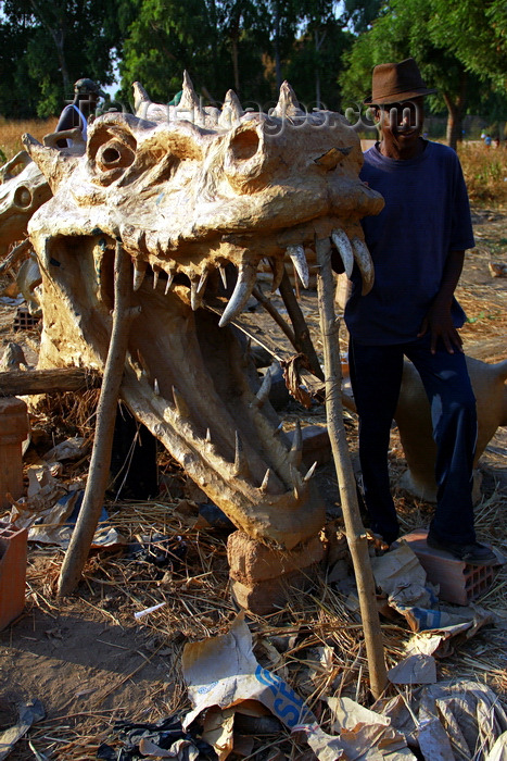 guinea-bissau96: Bissau, Guinea Bissau / Guiné Bissau: Bandim quarter, Carnival masks, mask of a dragon and a skull, man/ Bairro ‘Bandim’, máscaras de Carnaval, preparação, máscara de um dragão, homem - photo by R.V.Lopes - (c) Travel-Images.com - Stock Photography agency - Image Bank