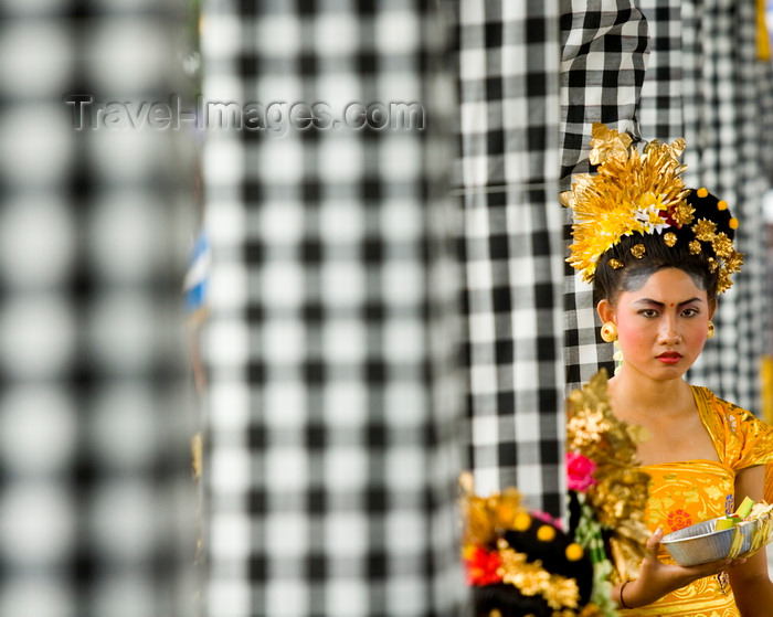 indonesia117: Padangbai, Bali, Indonesia: portrait of young Balinese woman wearing traditional costumes next to checked patterned cloth on columns - photo by D.Smith - (c) Travel-Images.com - Stock Photography agency - Image Bank