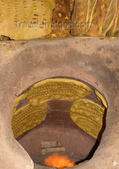 iran556: Yazd, Iran: baking bread in a tandoor, a cylindrical clay oven - photo by N.Mahmudova - (c) Travel-Images.com - Stock Photography agency - Image Bank