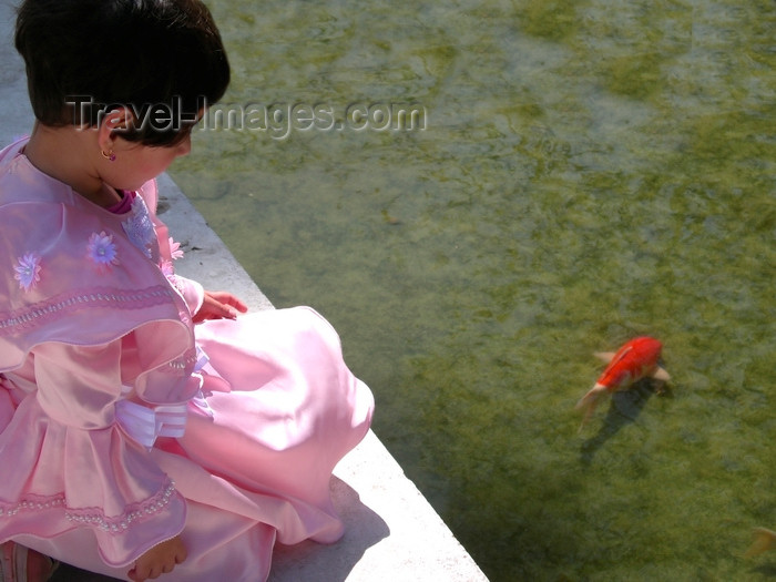 israel392: Israel: small girl dressed-up for the Purim celebrations, watching the fish in a pond - photo by E.Keren - (c) Travel-Images.com - Stock Photography agency - Image Bank