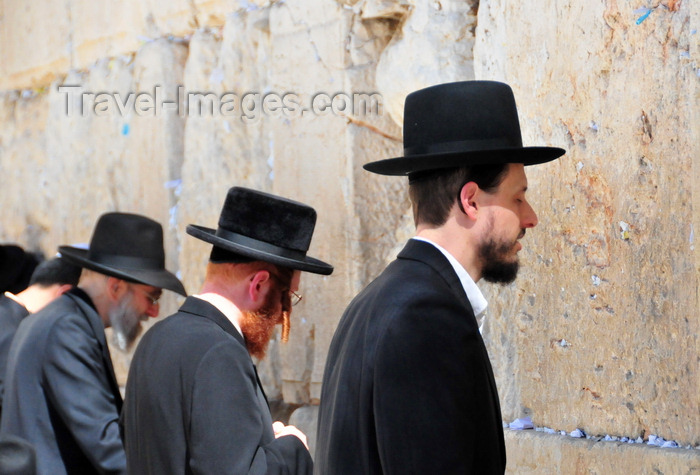 israel400: Jerusalem, Israel: line of Ortodox Jews in their traditional black clothing praying at the Wailing wall - as no mortar was used in the masonry, the lower joints between the chalky, yellow-white ashlar blocks have been stuffed with bits of paper containing prayers / Western Wall / the Kotel - muro das lamentações - Mur des Lamentations - Klagemauer - photo by M.Torres - (c) Travel-Images.com - Stock Photography agency - Image Bank